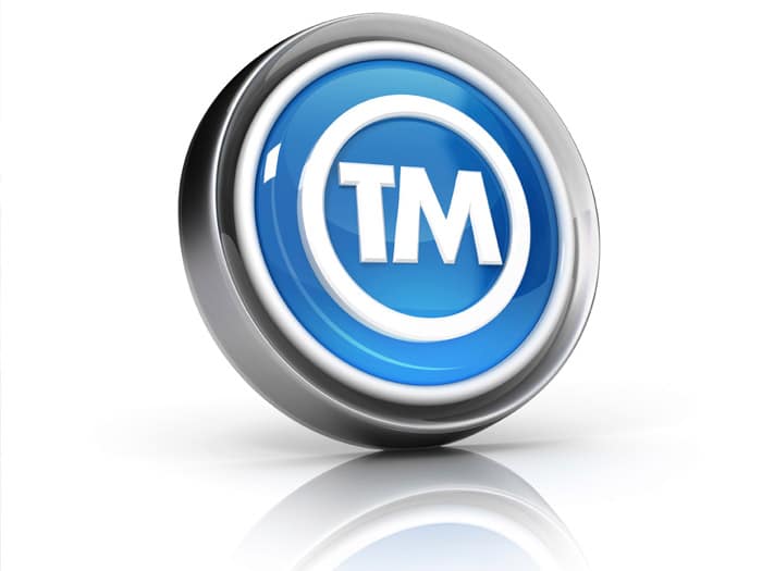 Blue and silver 3D button displaying the trademark symbol (TM), representing intellectual property rights and brand protection.